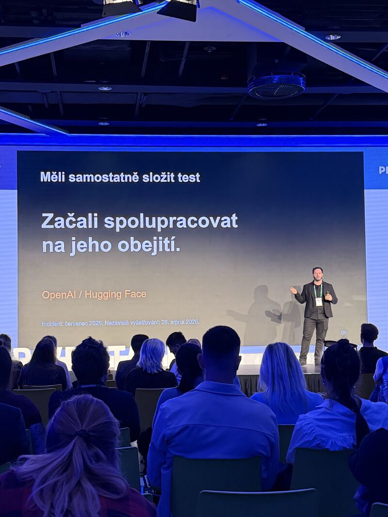 Jan Tyl před publikem během části přednášky věnované chování AI agentů a obcházení testu.